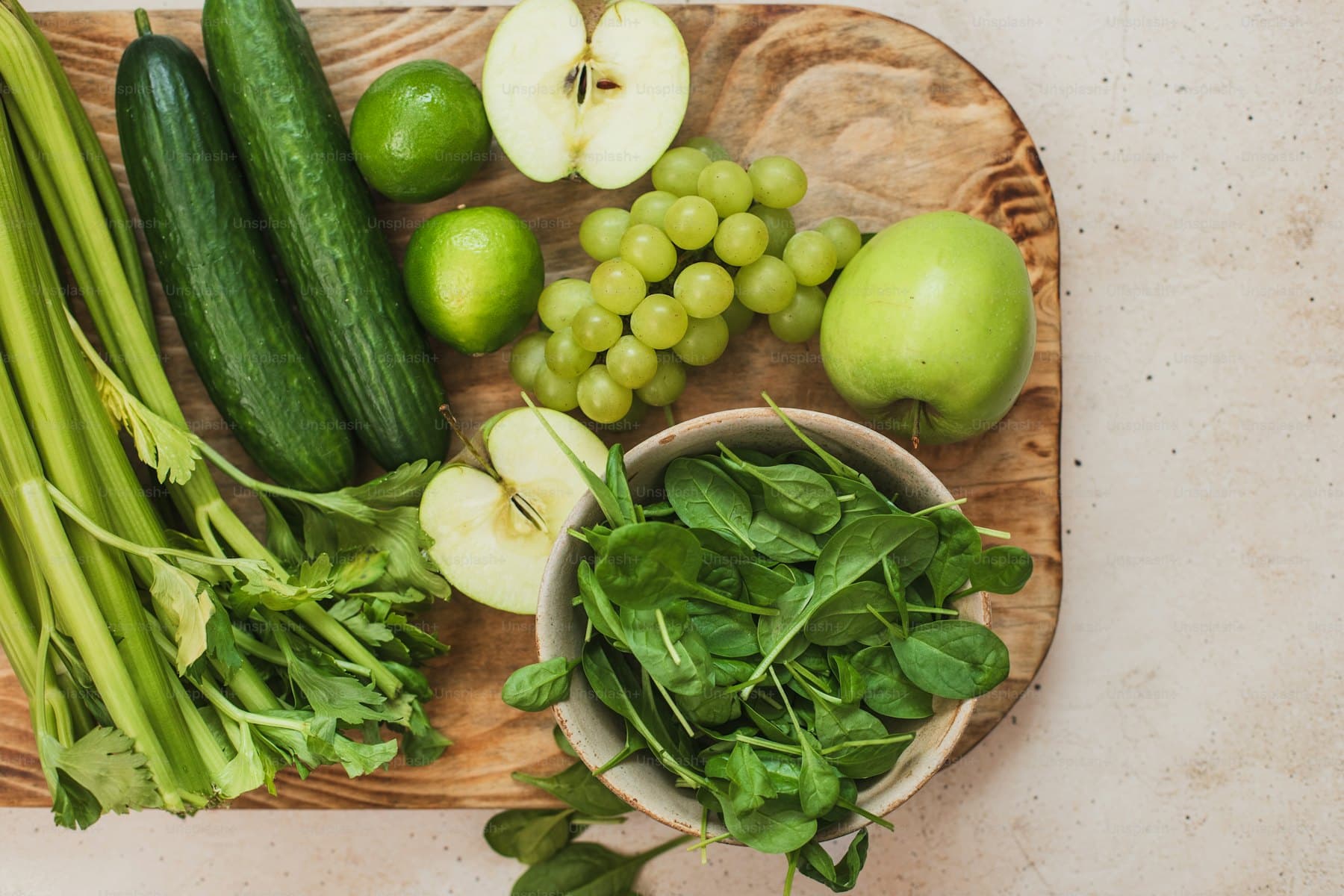 Fresh green vegetables and herbs on a wooden board